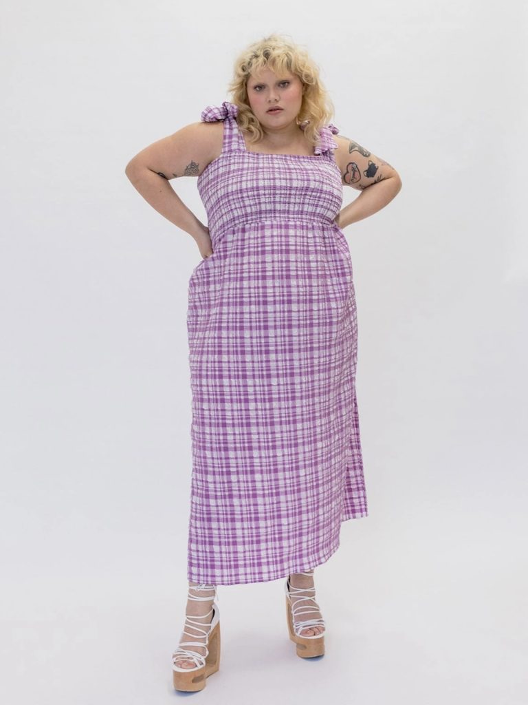 A sleeveless long dress with a purple and white gingham pattern.