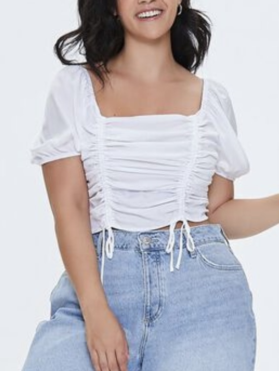 A white short-sleeved smocked crop top.