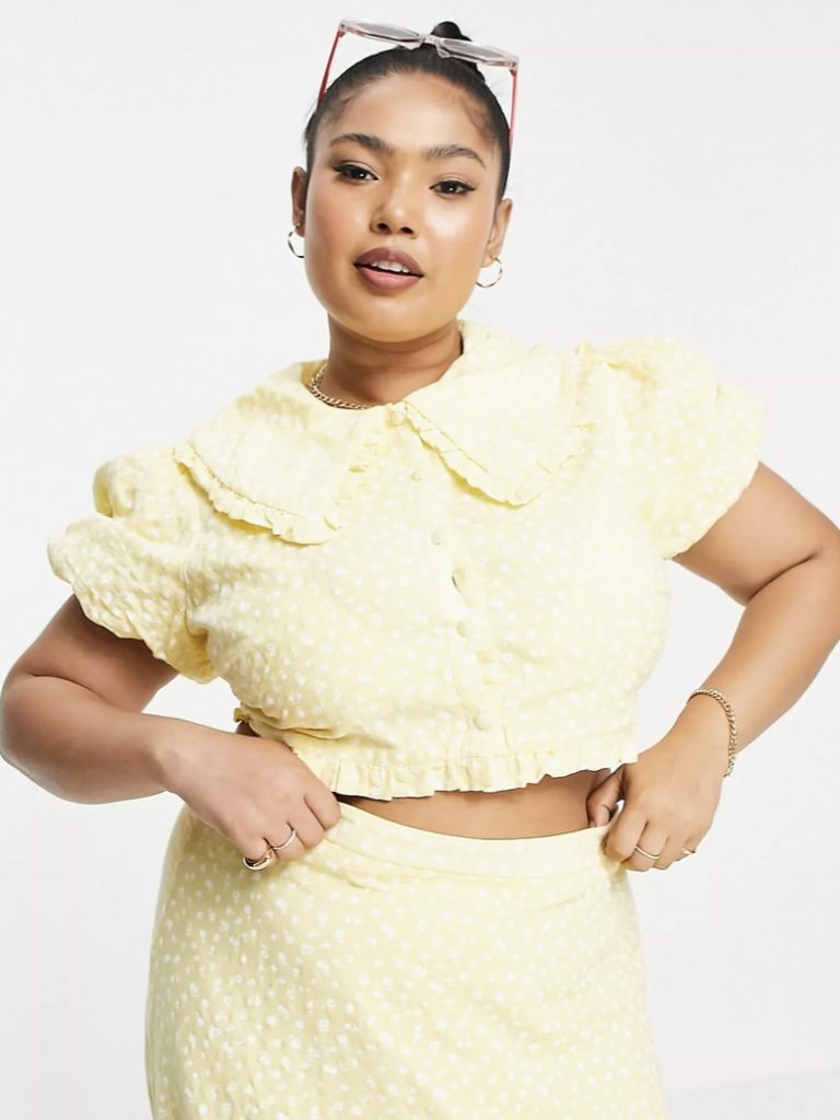 A pale yellow short-sleeved blouse with floral patterns.