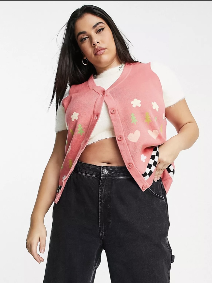 A pink sleeveless sweater with some colorful patterns.