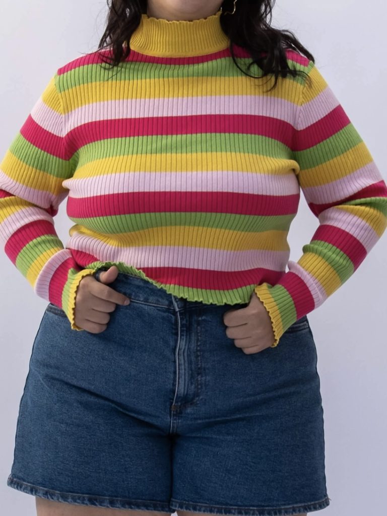 A turtleneck sweater with magenta, green, yellow, and white stripes.