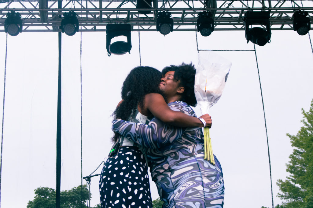 Akenya and Noname hugging each other after the former gave her flowers.