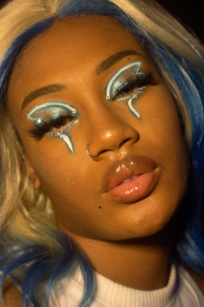 Close up of Ellie, a Black person in a makeup look inspired by NCT 127's Neo Seoul Nightclub. 