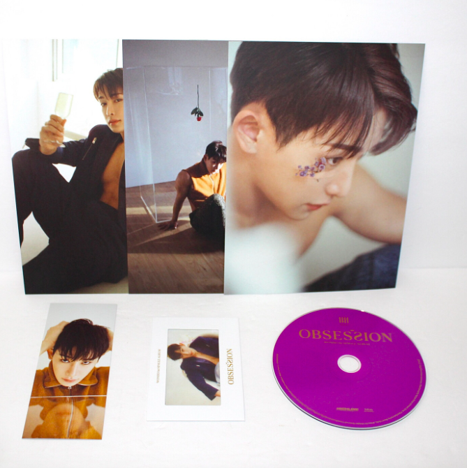 A detailed look of K-pop singer WONHO's first single album, Obsession, which includes a CD, a small card, three posters, and one bookmark. From K-Universe Thrift.