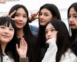 NewJeans taking a group selfie from their variety show, NewJeans Code in Busan.
