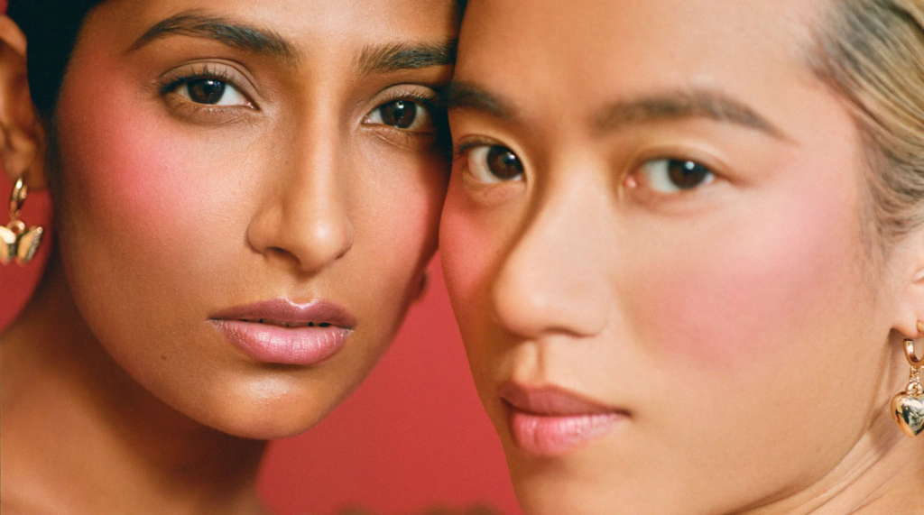 Kulfi Beauty - A close-up image of two people posing with their sides of heads touching each other.