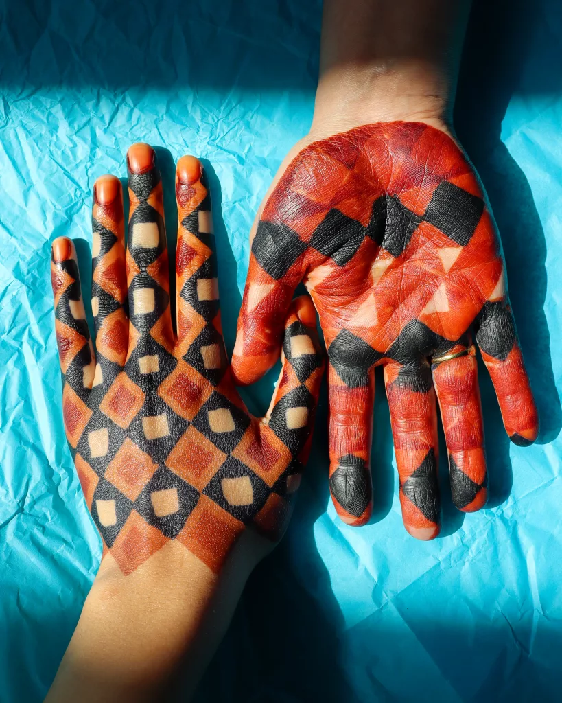 Two hands decorated with henna art.