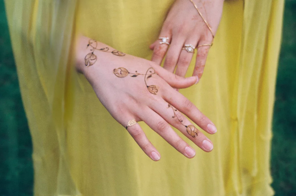 Golden flowers painted on a hand.
