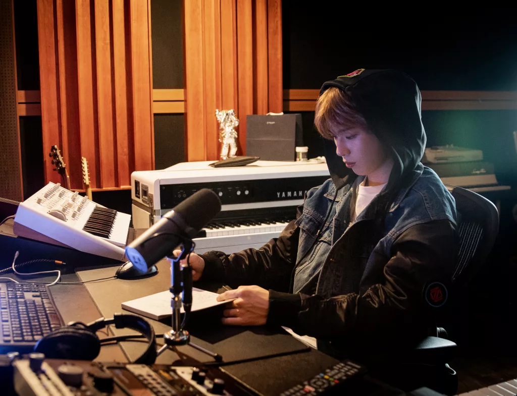 KANGDANIEL behind-the-scenes image, sitting in a recording studio.