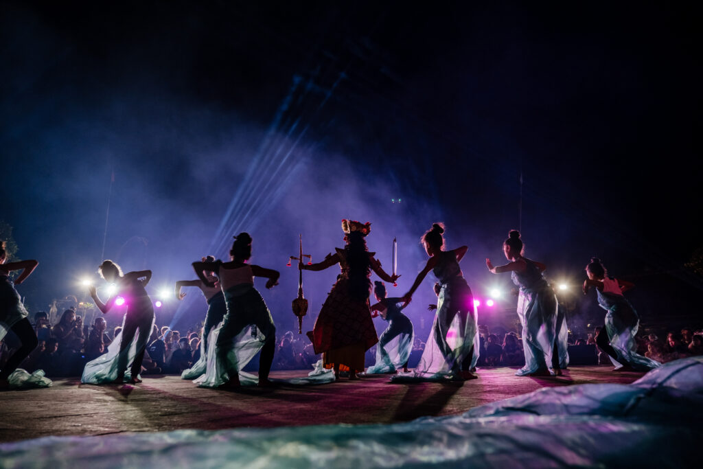 A group of dancers on stage, shot from behind. 