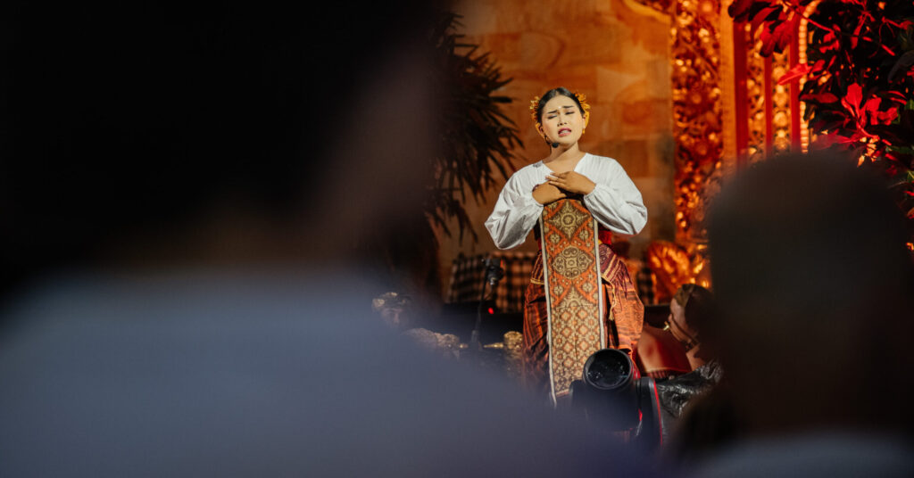 A woman standing on stage in an Ubud Writers & Readers Festival event.